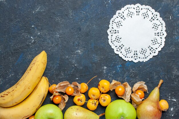 Vista superior de plátanos amarillos par de bayas con manzanas verdes frescas, peras, cerezas dulces en el escritorio azul oscuro, frutas, bayas, vitamina de salud