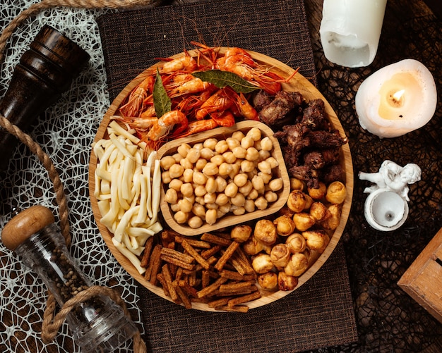 Foto gratuita vista superior de un plato de aperitivos de cerveza redonda con garbanzos de camarones y queso de cadena