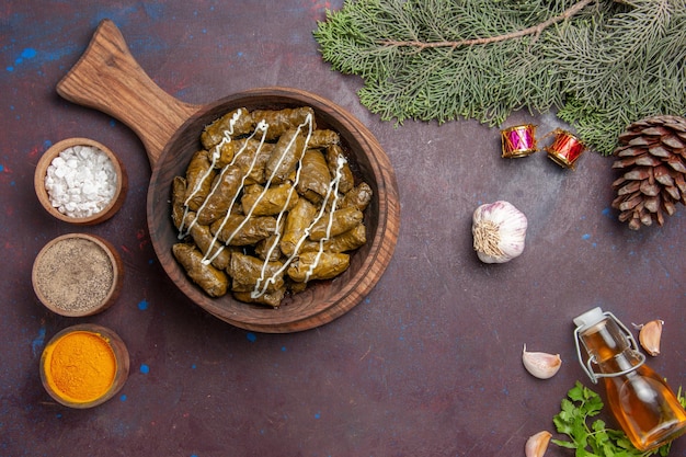 Vista superior del plato de carne de dolma de hoja deliciosa con diferentes condimentos en el fondo oscuro plato de cena de carne color de calorías de alimentos