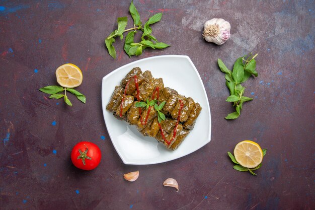 Vista superior del plato de carne molida de dolma de hoja deliciosa dentro de la placa sobre el fondo oscuro plato de carne hoja cena comida