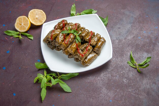 Vista superior del plato de carne molida de dolma de hoja deliciosa dentro de la placa sobre el fondo oscuro plato de carne hoja cena comida