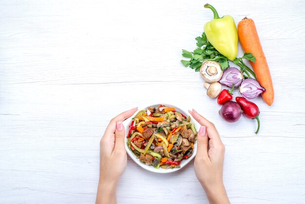 Vista superior del plato de carne en rodajas con verduras cocidas junto con verduras frescas en la mesa de luz comida comida plato carne