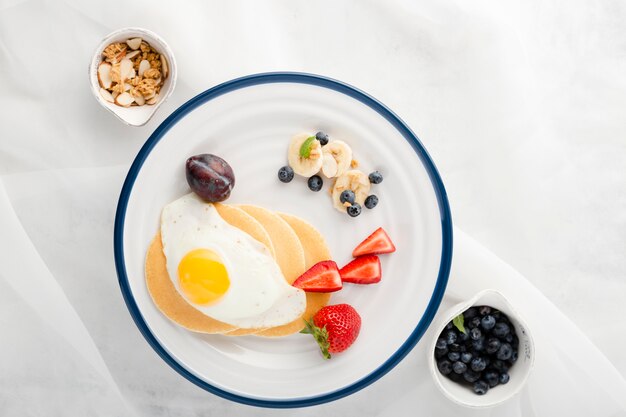 Vista superior plato de desayuno con huevos y panqueques