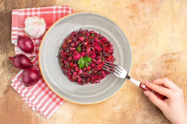 Vista superior del plato de una ensalada roja con verduras sobre un fondo de madera