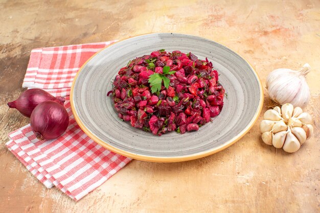 Vista superior del plato de una ensalada roja con verduras sobre un fondo de madera