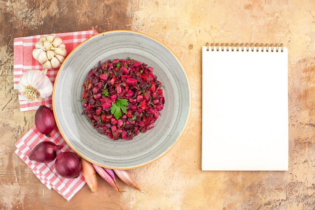 Vista superior del plato de una ensalada roja con verduras sobre un fondo de madera