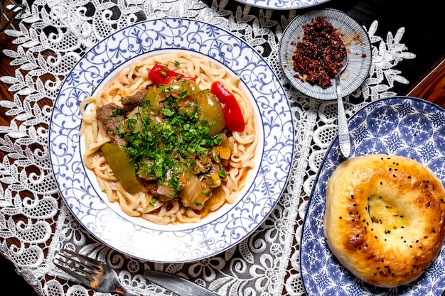 Foto gratuita vista superior del plato de fideos adornado con pimientos salteados de cordero y hierbas