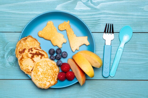 Vista superior del plato con frutas y panqueques para comida para bebés
