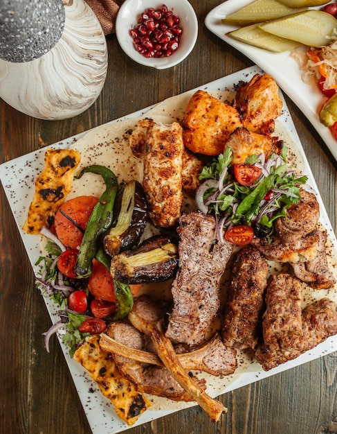 Vista superior del plato de kebab con costillas de pollo lula tikka y verduras kebab
