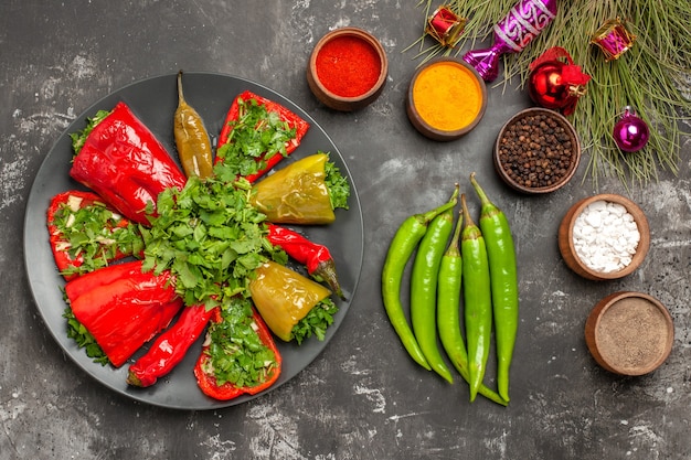 Vista superior del plato de pimientos con hierbas pimientos picantes especias juguetes del árbol de Navidad