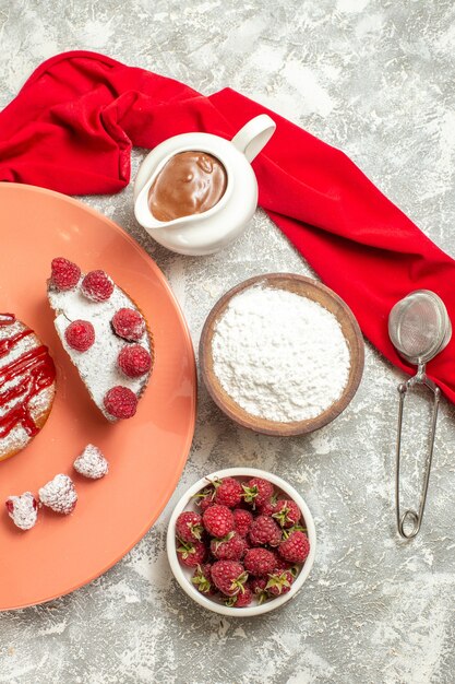 Vista superior del plato de postre dulce con bayas de tamiz de té de chocolate y servilleta roja en el lado sobre fondo de mármol