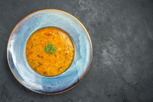 Vista superior del plato de sopa de una apetitosa sopa con hierbas sobre la mesa