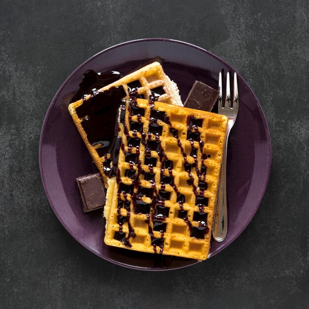 Vista superior del plato con waffles y salsa de chocolate