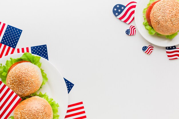 Vista superior de platos con banderas americanas y hamburguesas
