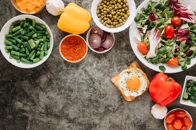 Foto gratuita vista superior de platos con ensalada y huevo frito sobre tostadas