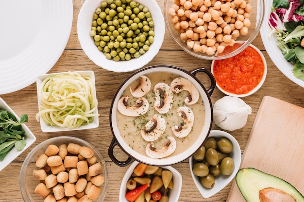 Vista superior de platos con sopa de champiñones y aceitunas