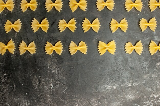 Foto gratuita vista superior poco de pasta cruda forrada sobre un fondo gris oscuro