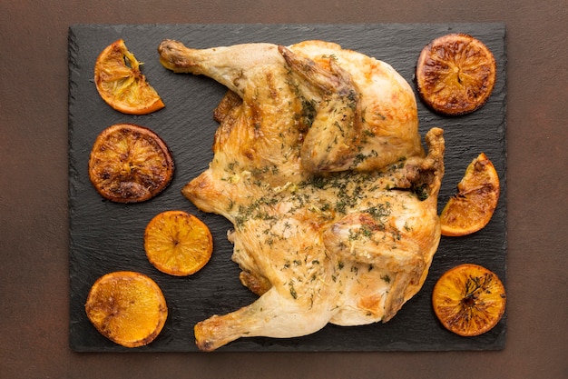 Vista superior de pollo al horno con rodajas de naranja