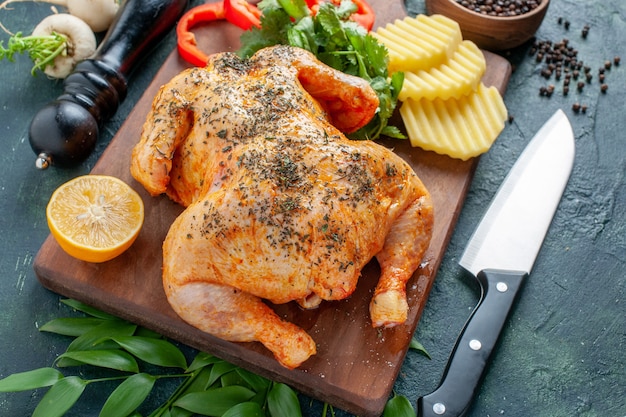 Vista superior de pollo cocido condimentado con patatas en la superficie oscura