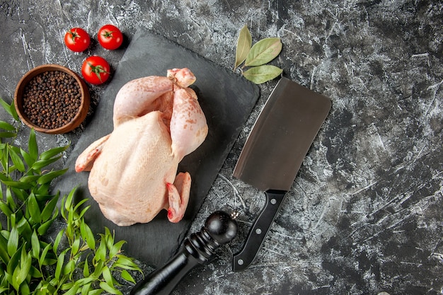 Vista superior pollo crudo fresco con tomates sobre fondo claro-oscuro comida de cocina foto de animal comida de color de carne de pollo