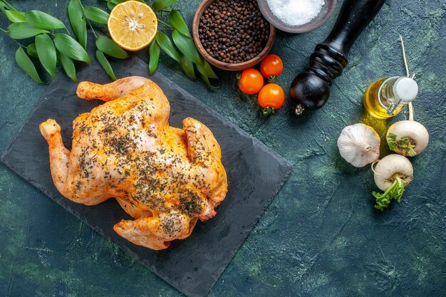 Vista superior de pollo con especias cocidas en la superficie oscura