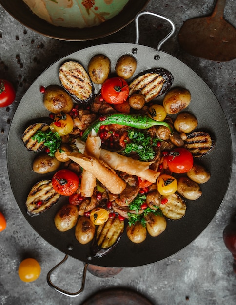 vista superior de pollo saj con pimiento, berenjena, tomates, papas y pan plano