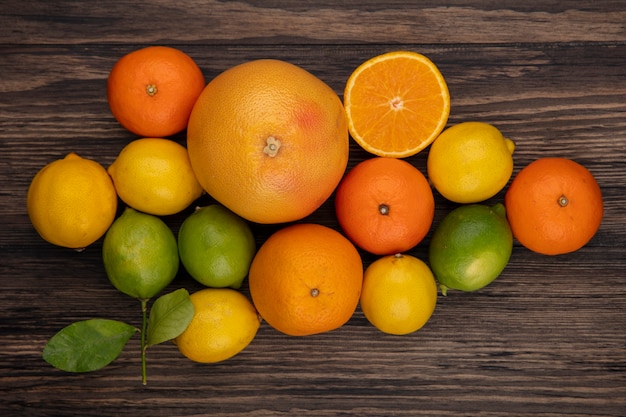 Vista superior de pomelo con naranjas limones y limas sobre fondo de madera