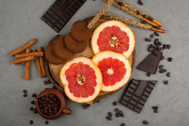 Foto gratuita vista superior pomelos galletas chocolate en rodajas jugosas en el escritorio gris