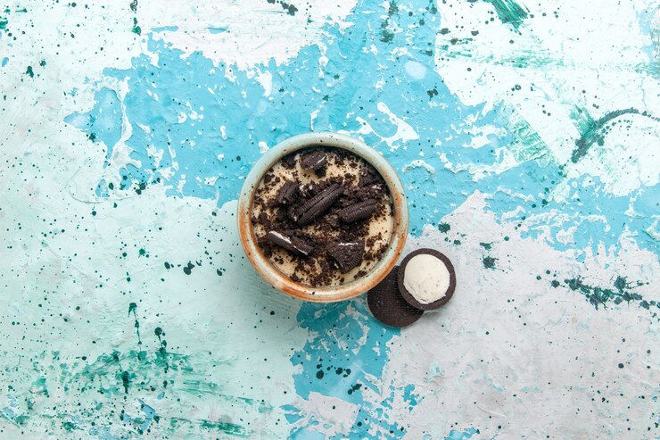 Foto gratuito vista superior de postre de galleta de chocolate con crema y galletas dentro de la placa sobre el fondo azul pastel postre azúcar dulce color