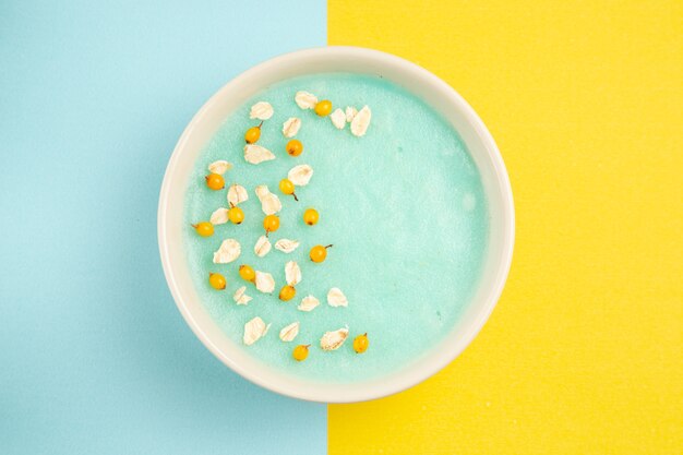 Vista superior de postre helado azul dentro de la placa en el cereal de color leche de mesa azul-amarillo