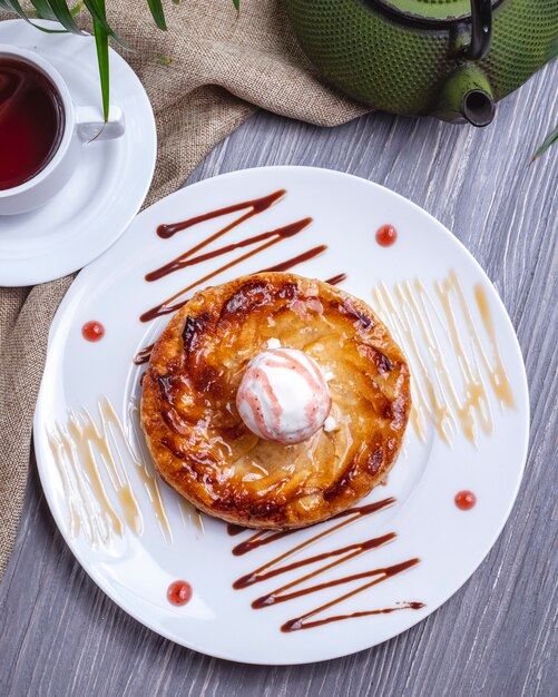 Vista superior postre con helado con glaseado y una taza de té