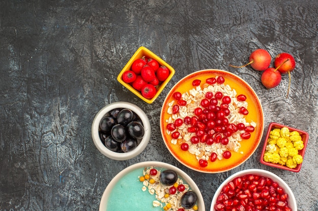 Vista superior de primer plano bayas la apetitosa avena cerezas grosellas rojas uvas granadas