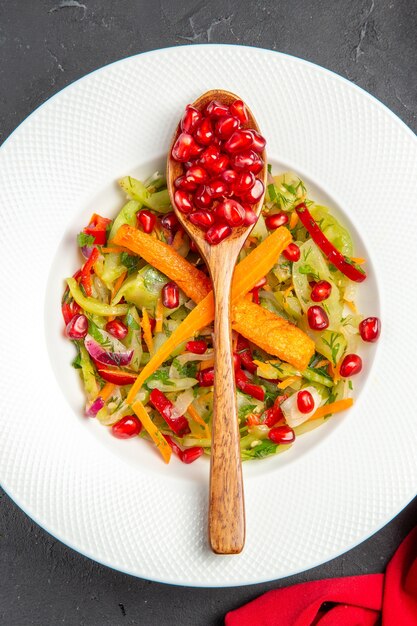 Vista superior de primer plano cuchara de ensalada de verduras de granada con semillas de granadas