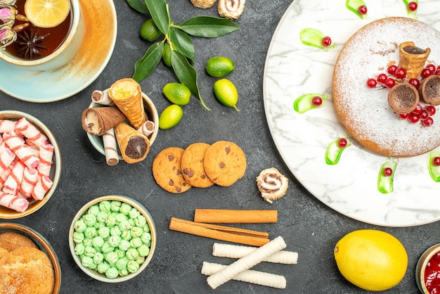 Vista superior de primer plano dulces una taza de té un pastel con gofres galletas dulces mermelada