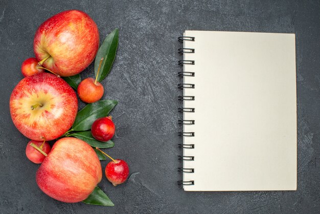 Vista superior de primer plano frutas las apetitosas bayas y frutas con cuaderno de hojas