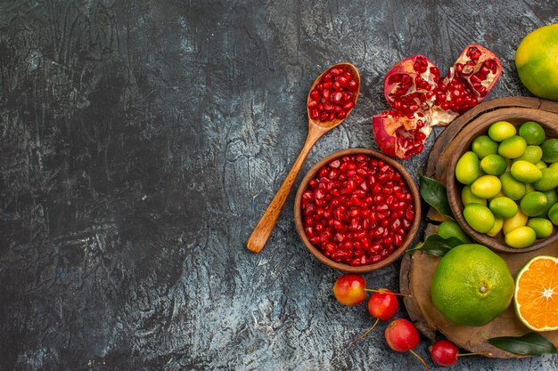 Vista superior de primer plano frutas cítricas semillas de granada frutas cítricas en la tabla de cortar