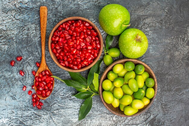 Vista superior de primer plano frutas manzanas semillas de fruta cítrica de cuchara de granada en el tazón de fuente