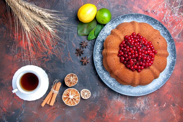 Vista superior de primer plano pastel limones canela una taza de té pastel de anís estrellado con grosellas rojas