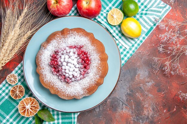Vista superior de primer plano un pastel un pastel con grosellas rojas y azúcar en polvo cítricos manzanas