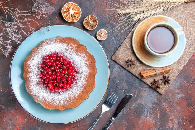 Vista superior de primer plano pastel un pastel una taza de té canela anís estrellado limón cuchillo tenedor