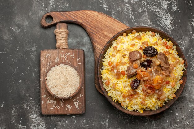 Vista superior de primer plano pilaf un apetitoso pilaf en el plato tazón de fuente de arroz en la tabla de cortar