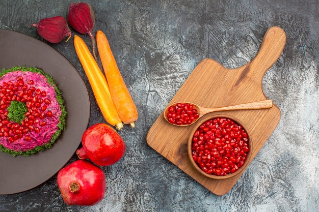 Vista superior de primer plano plato de Navidad plato granadas verduras la tabla de cortar con granada