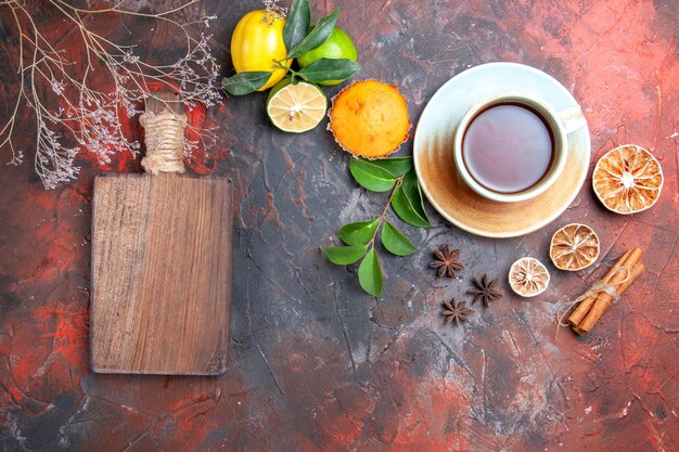 Vista superior de primer plano una taza de té cupcake una taza de té negro la tabla de cortar limón anís estrellado