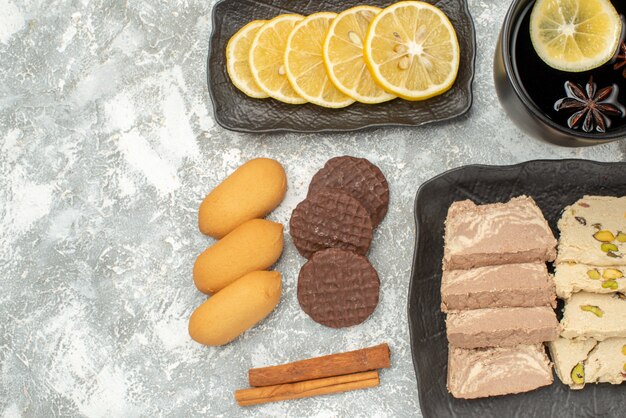 Vista superior de primer plano una taza de té una taza de té galletas de canela dulces de limón en el plato