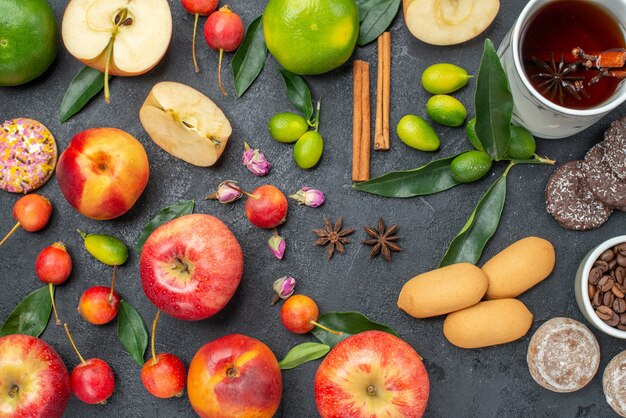 Vista superior de primer plano una taza de té una taza de té de hierbas dulces frutas y bayas palitos de canela