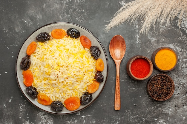 Vista superior del primer plato de arroz de arroz con frutos secos cuchara especias coloridas