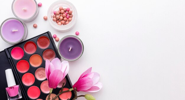 Vista superior de productos de maquillaje y velas con espacio de copia