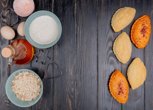 Vista superior de productos de panadería como shakarbura con harina de copos de avena mantequilla sobre fondo de madera con espacio de copia