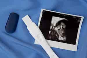 Foto gratuita vista superior prueba de embarazo positiva y ultrasonido