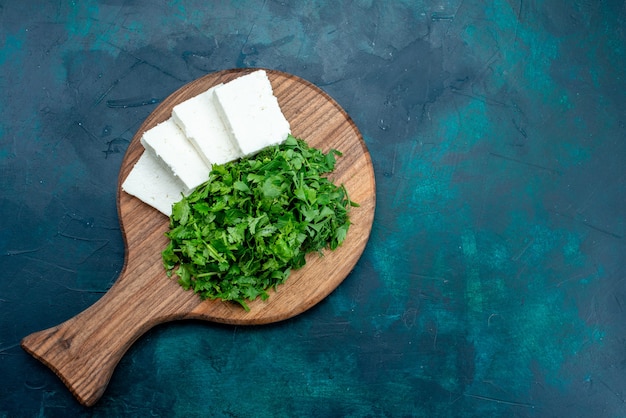 Foto gratuita vista superior de queso blanco con verduras frescas sobre superficie azul oscuro